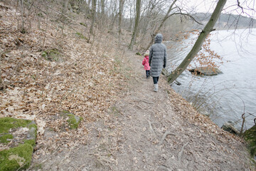 Obraz premium Mother and a child girl hiking in the forest
