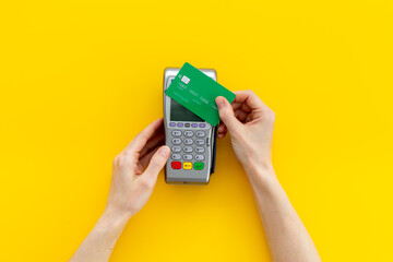 Female holding in hands bank terminal for contactless payment by credit cards. Banking and shopping concept