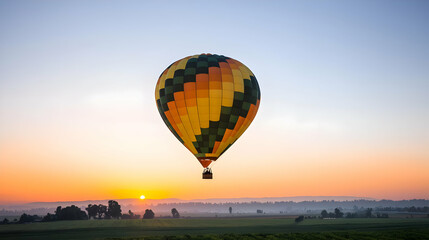 Obraz premium Colorful Hot Air Balloon Floating Above Fields During A Vibrant Sunrise
