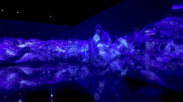 Immersive installation featuring vibrant blue waves, creating dynamic reflections on the floor, enveloping the space in colorful energy