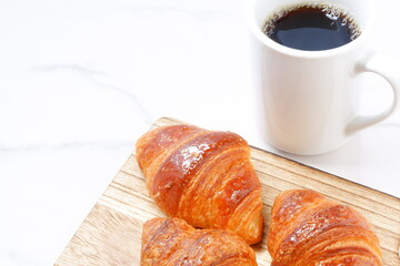 焼き立てでサクサクの食感のクロワッサンと、淹れたてのコーヒーの朝食風景
