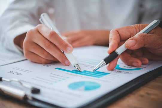 Business team working with laptop and calculator in open space office. Meeting report in progress