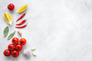 Cooking concept with tomatoes and chili peppers, vegetables spices on the kitchen desk top
