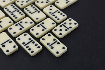 Flat lay composition of chess pieces and dominoes on dark table