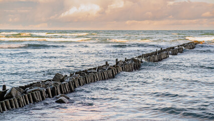 Calm Waves and Dramatic Clouds Over Serene Seascape During Late Afternoon Near Coastal Shore