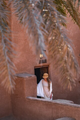 Tourist woman walking down the stairs of traditional moroccan earthen house