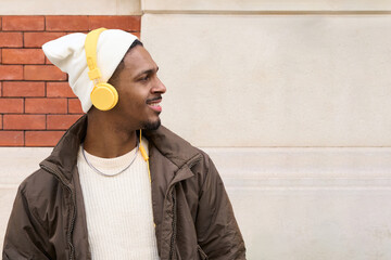 Young man listening to music with headphones and smiling