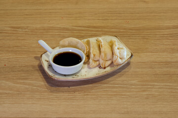 A plate of dumplings with sauce and a spoon