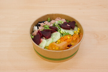 A salad with a variety of vegetables including tomatoes, carrots, and radishes