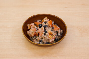 A bowl of food with a variety of ingredients including tomatoes and beans