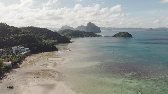 Drone flight over Corong Corong Beach with boats along the shore, offering a scenic view of the beach and Las Cabanas in the distance.
