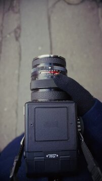 Closing The Viewfinder Of A Classic Camera While Walking The Streets