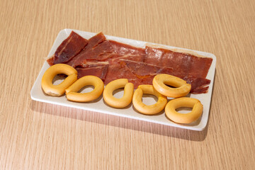 A plate of meat and a plate of doughnuts