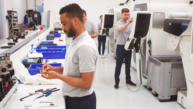 Male Engineer Measuring Components In Hi Tech Engineering Plant