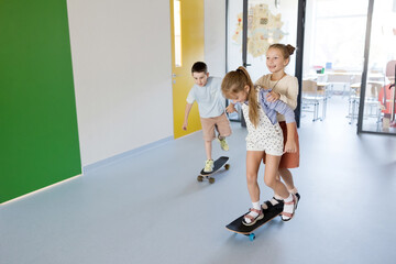 Schoolchildren with skateboard at school hallway