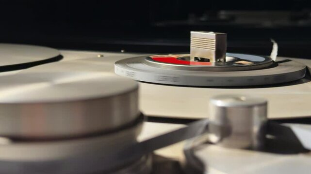 Close up of professional vintage Studier magnetophone recording reel-to-reel audio tape in dark room