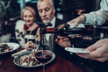 Waiter pours wine and Businessman stops him