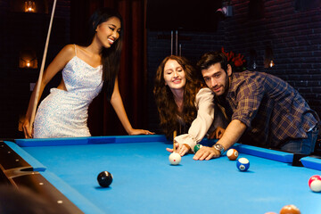 A group of friends enjoys a fun night out playing pool in a stylish billiards lounge. A relaxed social atmosphere, laughter, and friendly competition in an upscale nightlife setting.