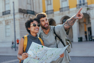 Tourists looking map and pointing in city center