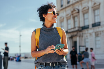 Tourist using smart phone and exploring city during summer vacation