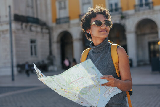 Tourist exploring lisbon with map and backpack enjoying summer vacations
