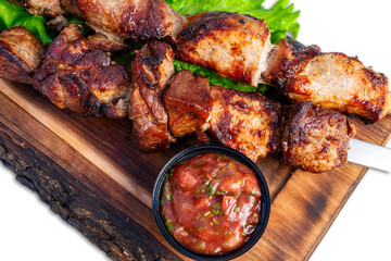 Delicious grilled meat skewers served with fresh salsa on a platter