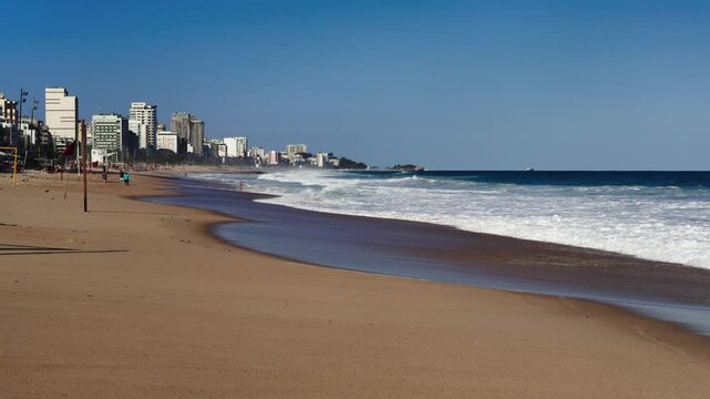 Beautiful waves roll onto a sandy beach in downtown of Rio de Janeiro, Brazil.