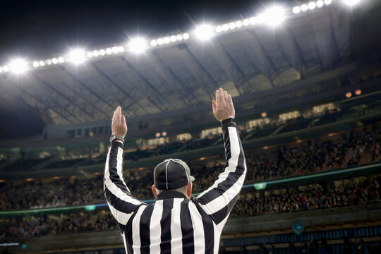 Football Referee Signaling Touchdown During Game Under Bright Stadium Lights