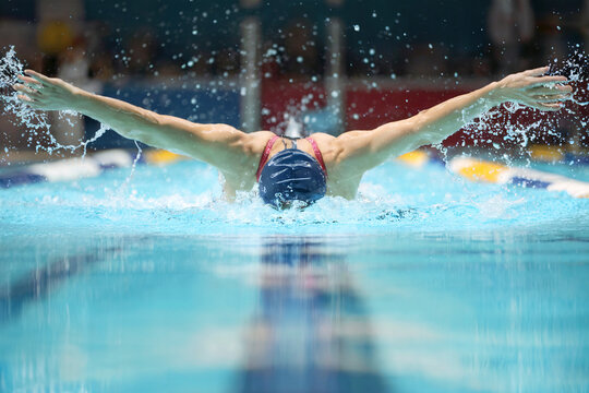 Professional Swimmer Performing Butterfly Stroke in a Competitive Swimming Pool