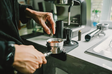 Close-up of coffee powder spreading in the brewing handle to prepare a coffee drink menu.