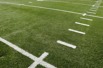 Obraz premium Green Grass Football Field with White Markings and Yard Lines Displayed