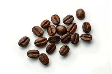 A small collection of coffee beans arranged in a scattered pattern against a plain white background.