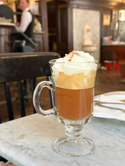 Coffee Maria Theresia with whipped cream and a sprinkle of cinnamon on top in a glass mu