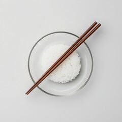 Bowl of white rice with chopsticks isolated on a white background.
