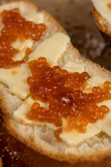 a soft loaf of wheat flour with butter and red salmon caviar