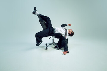 Entrepreneur balancing on chair and showing creative interpretation of business struggles with...