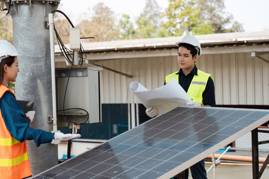 Inspecting solar panels for sustainable energy solutions. Engineers working on solar technology at an outdoor site.