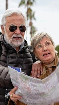 Senior couple of tourists sightseeing city street with map. Happy husband and wife enjoying vacation together