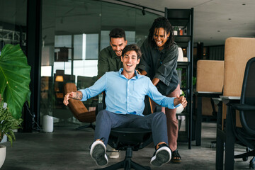 Overjoyed young multiethnic colleagues celebrating shared corporate success or goal achievement