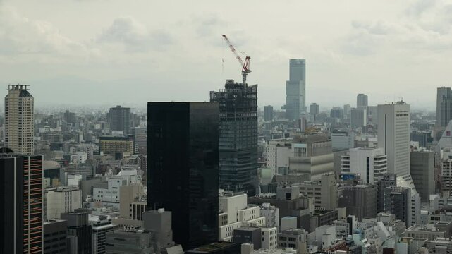 大坂で建築中の高層ビルとタワークレーンのタイムラプス映像（ズームイン）