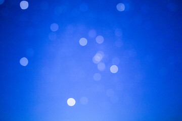 The photograph shows a blue background with blurred white circles. The circles create a bokeh effect, scattered across the background. The background is uniform, the color is saturated.