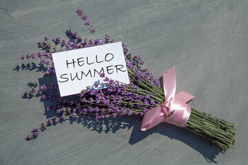 Hello Summer, greeting card. Lavender flowers in a bouquet on a gray textured background. form....