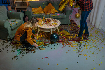 Couple Cleaning Golden Confetti After Birthday Party Celebration at Home