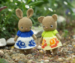 Cute knitted rabbit and knitted cat in dresses