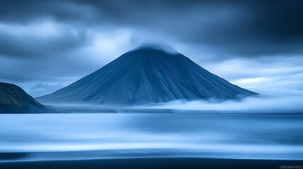 Moody mountain coast landscape with a fog-shrouded peak for travel uses