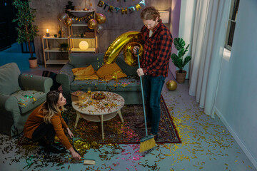 Couple Cleaning Golden Confetti After Birthday Party Celebration at Home