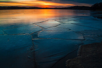 Beautiful sunset over frozen lake in Sweden showcasing fractured ice patterns