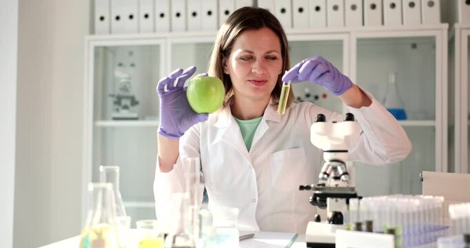 A knowledgeable scientist carefully analyzes a fresh apple using a test tube within a wellequipped laboratory setting