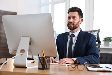 Man working on computer at table in office