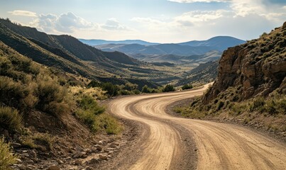 Winding dirt road through mountainous landscape in daylight